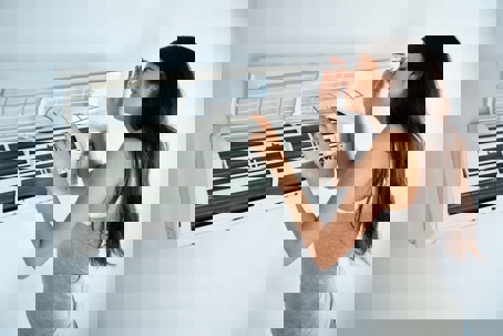 woman peering into mini-split system