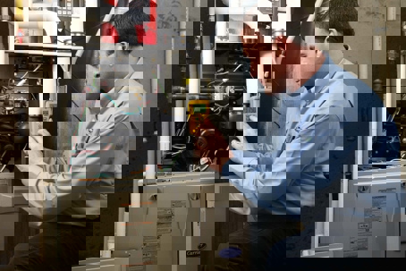 man inspecting HVAC system